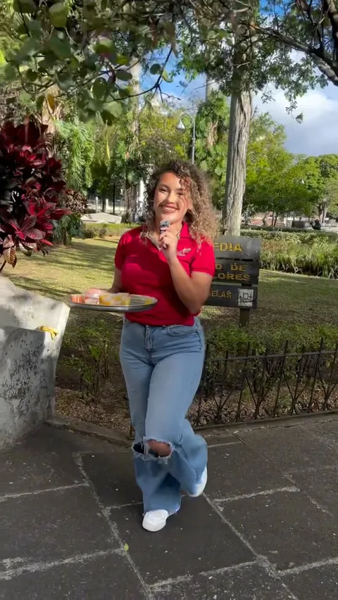 Persona con la polo roja de Vega's ofrece una bandeja de degustación en un parque